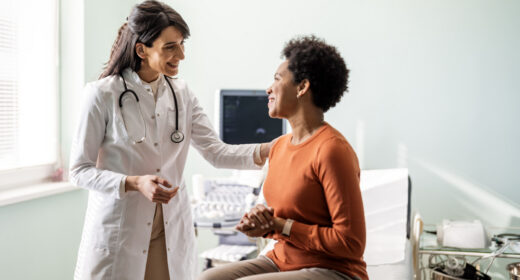 A doctor consults with a patient seated on an examination table.